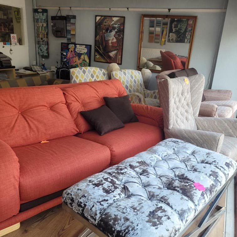 Coral sofa and buttoned footstool upholstered by Crown Upholstery